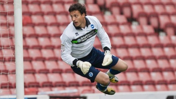 David Gonzalez wearing a white goalkeeper kit in goal for Brighton