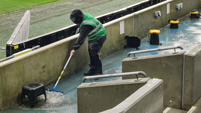 A steward at the Amex tries to sweep away the rain during Brighton 0-0 Arsenal