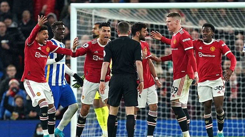 Manchester United players surround referee Mr Bankes to demand Lewis Dunk is sent off during their 2-0 win over Brighton